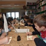 Warsztaty podróż w czasie - dzieci piszące gęsim piórem