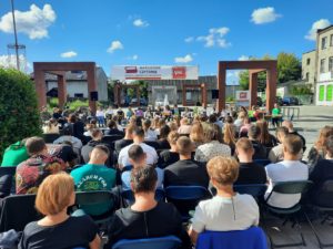 Narodowe czytanie 2022 - publiczność zgromadzona na placu przy fontannie w Łazach i lektorzy