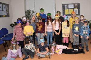 Grupa dzieci i młodzieży ubrana w karnawałowe maski